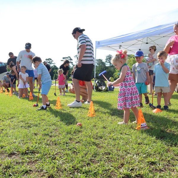 Families spread out across the practice stations on a sunny morning